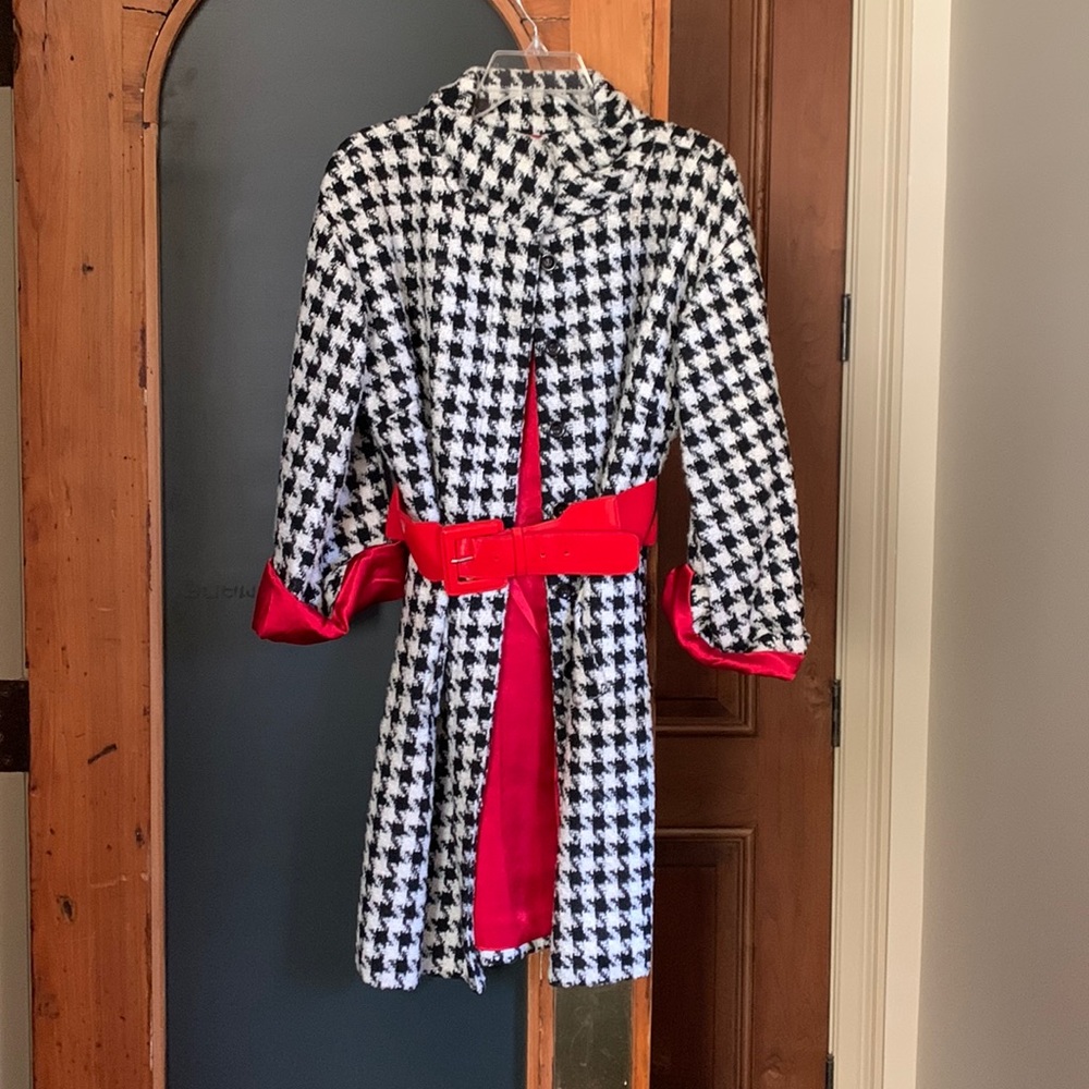 Black and white belted, houndstooth coat with red lining